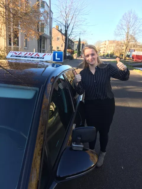 Geslaagde leerling van Autorijschool Sediki bij de VW Golf lesauto