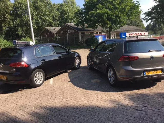 De lesauto’s van Autorijschool Sediki geparkeerd op een parkeerplaats in Gouda